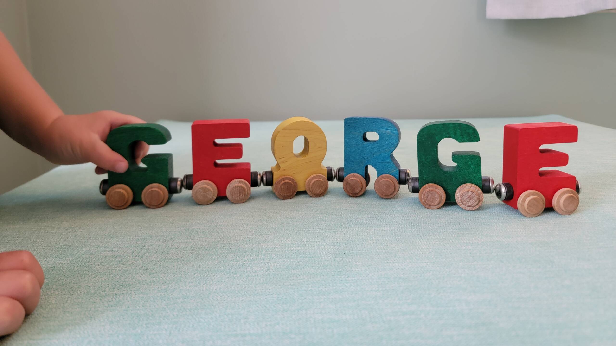 A wooden train made from the letters of the name George