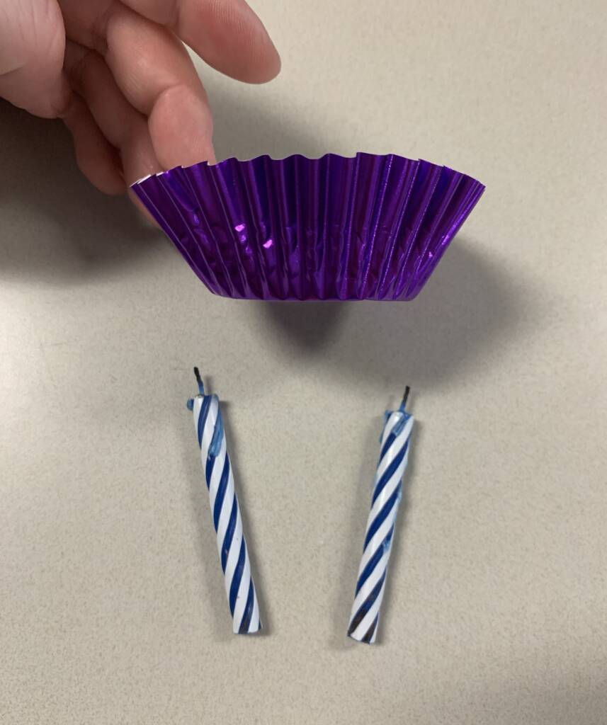 Cupcake wrapper and two birthday candles.