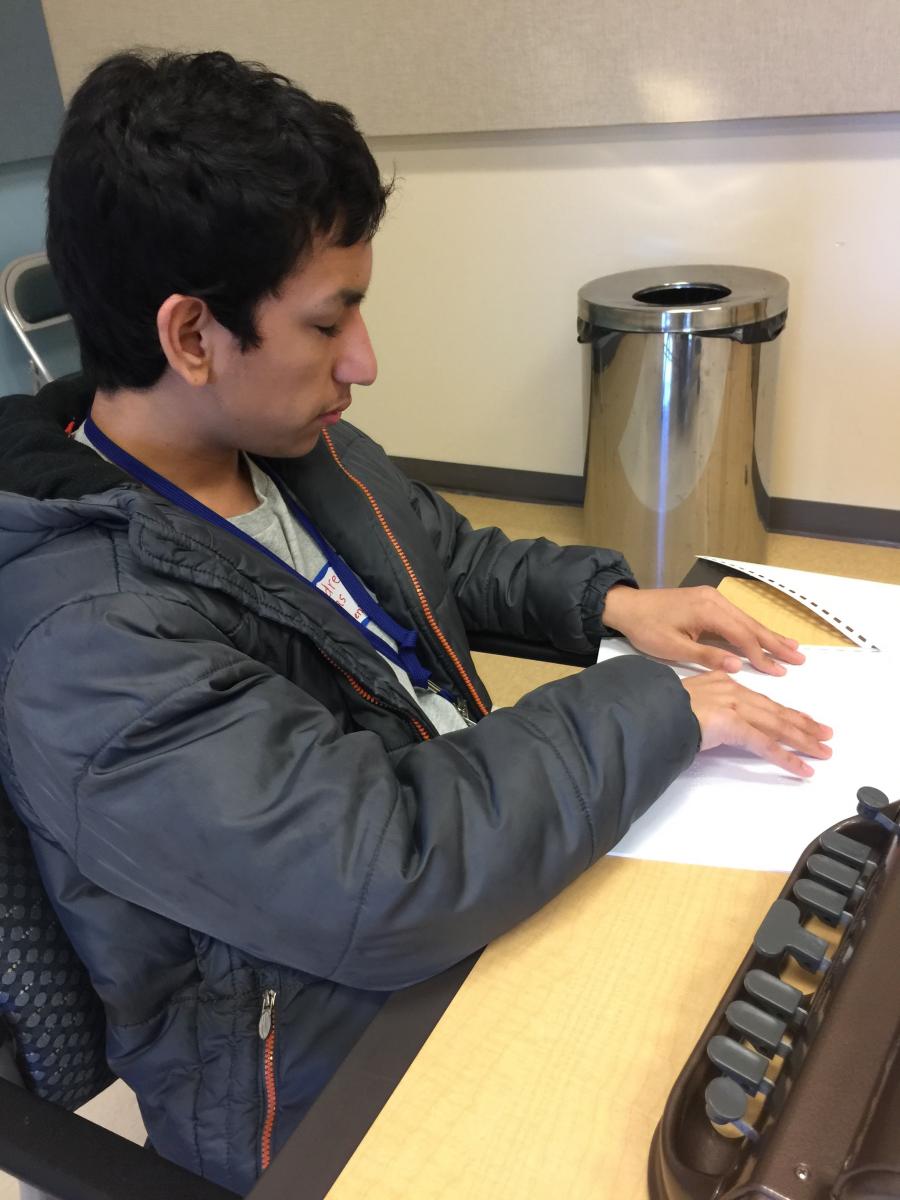 A boy reads a braille text during the Braille Challenge.