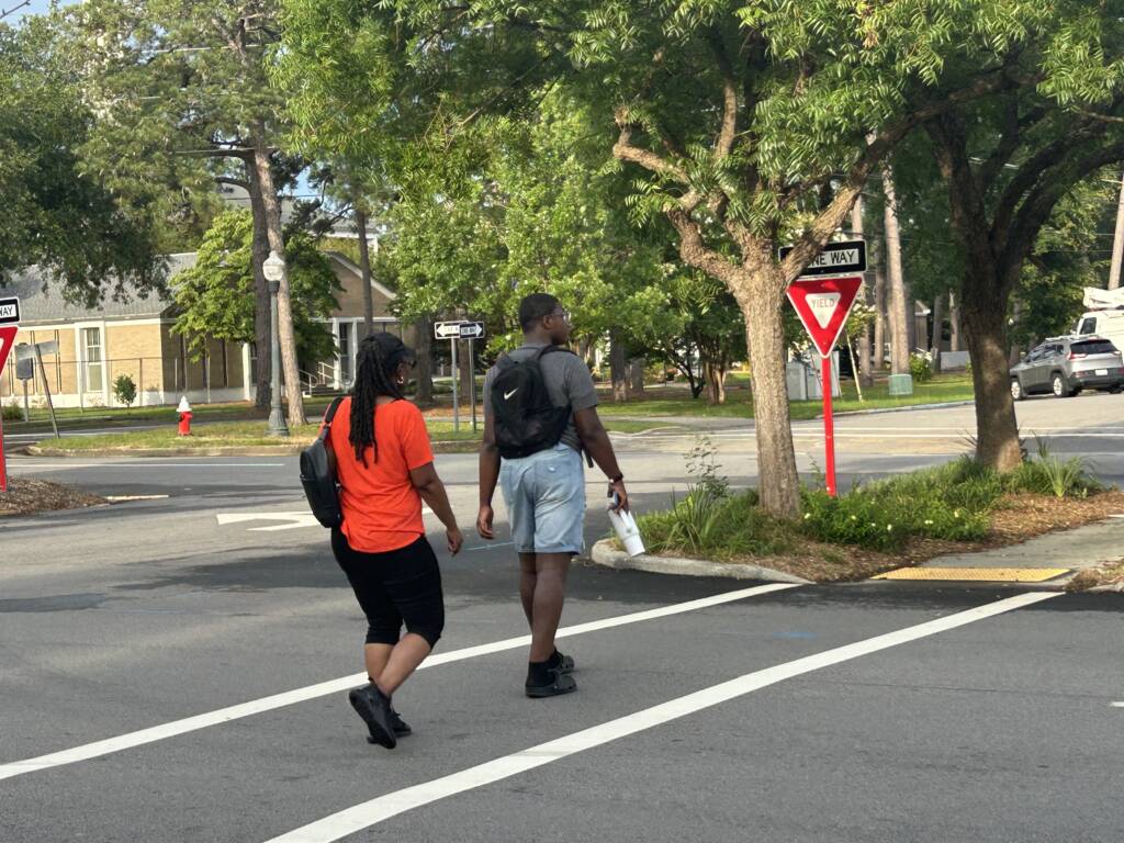 Two people crossing the street in a crosswalk