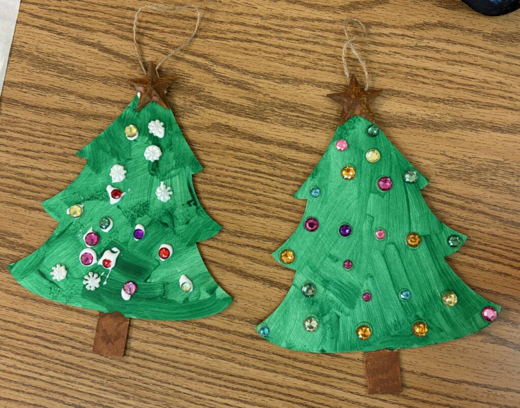 Two painted and decorated wooden Christmas trees.