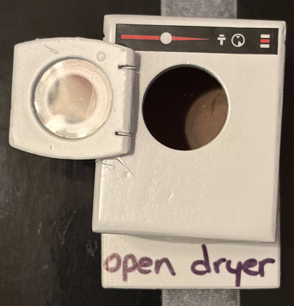 Tactile symbol for dryer that has a mini dryer front on it. 