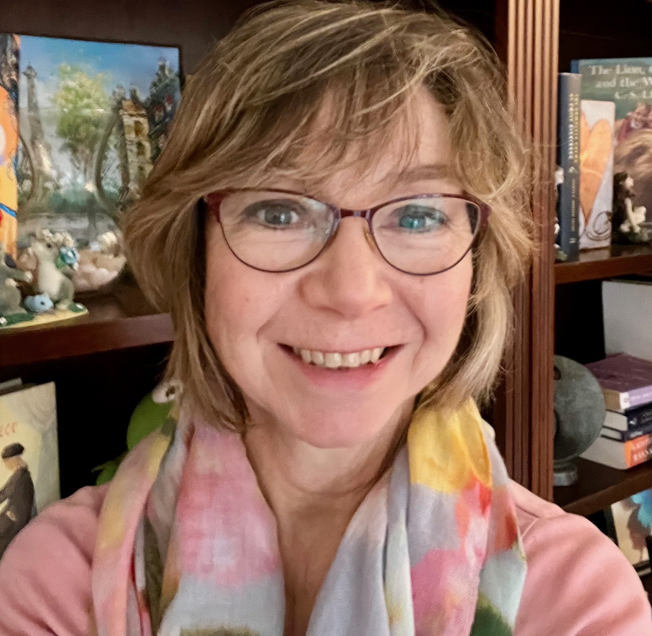 Janice Milusich smiling with glasses on and a pretty scarf around her neck.
