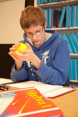 A student holds a 3-dimensional geometric shape