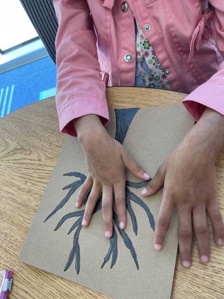 Student touching the bare tree to explore the branches. 