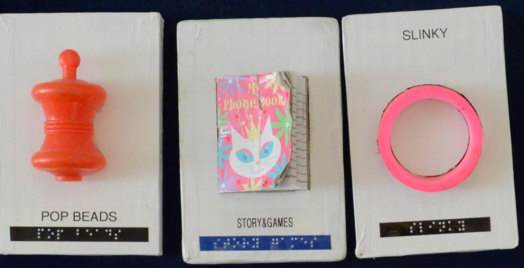 Toys embedded on triwall cards with braille labels