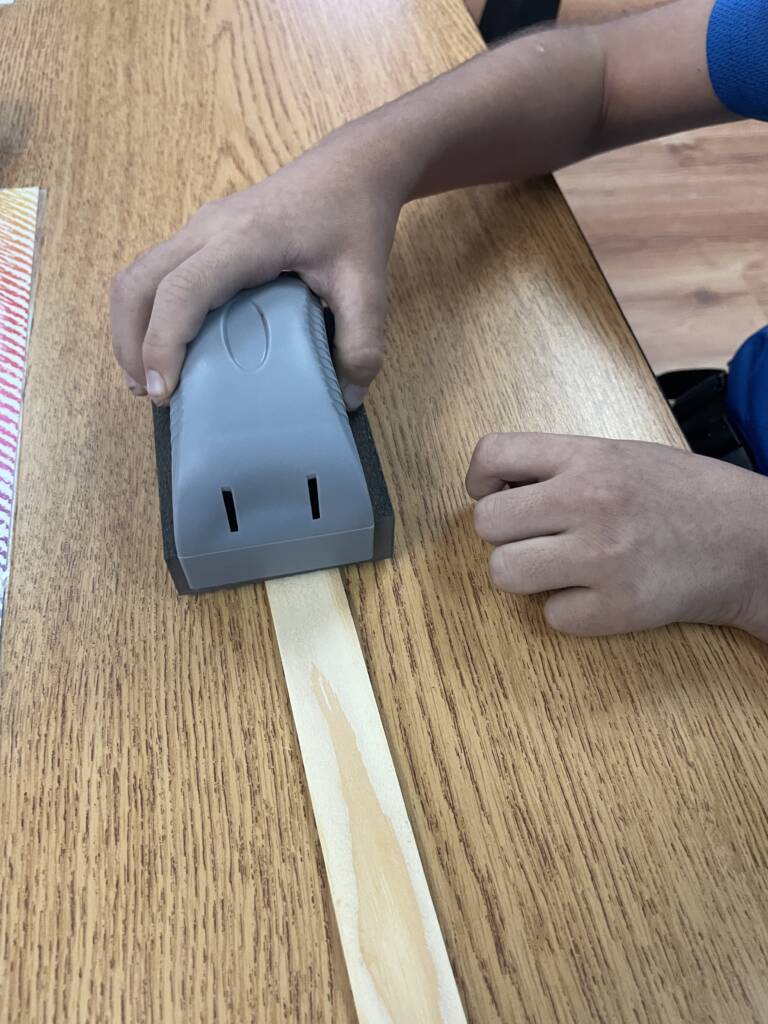 Students sanding a ruler. 