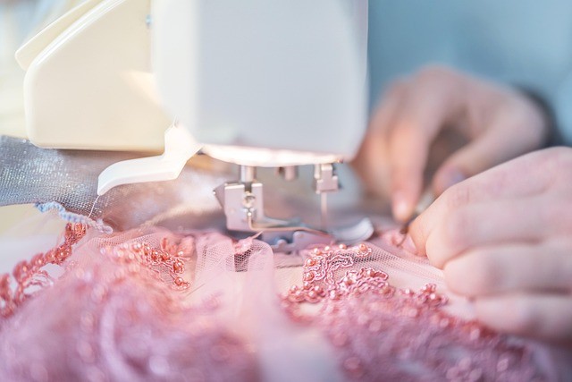 Teen sewing a pretty, beaded dress with a tabletop sewing machine. 