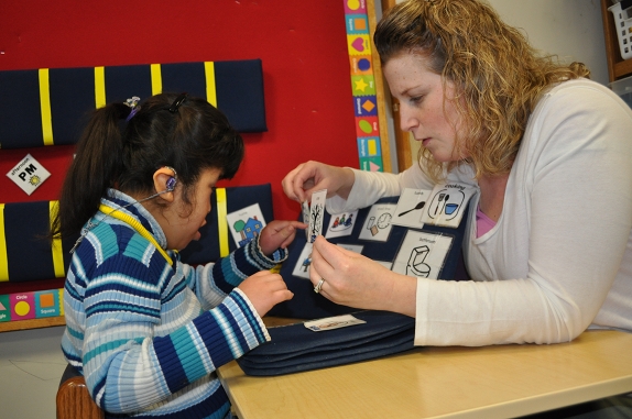 A woman and child are working on a tactile activity together.