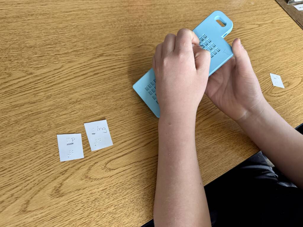 Liam's hands creating the mystery word on the Versa slate.
