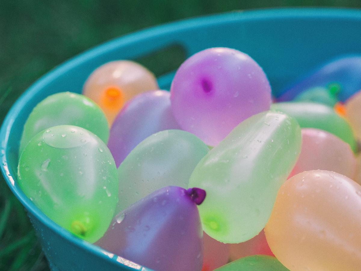 Colorful water balloons in a plastic tub
