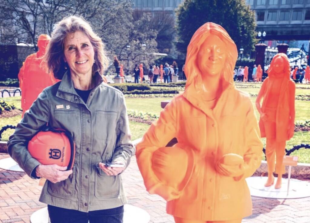 Dr. Lindsey Rustad standing beside her life-sized 3D printed statue at the Smithsonian.