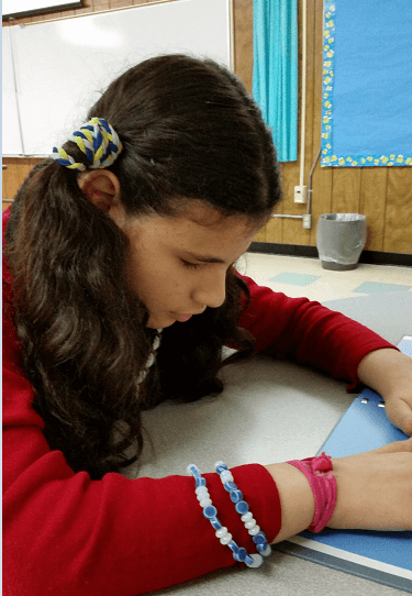 A girl reads a braille text.