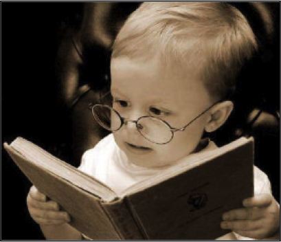 baby with glasses reading a book